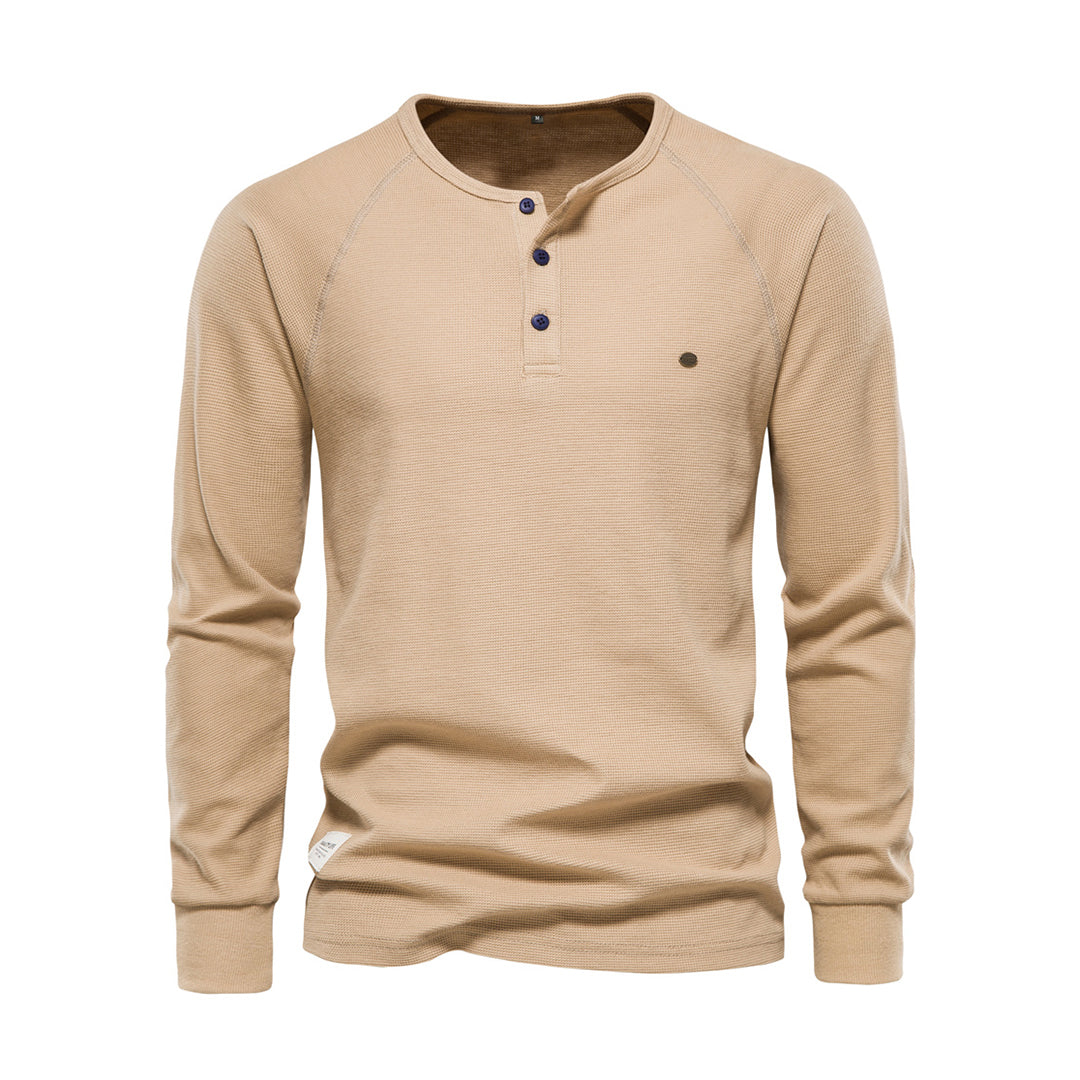 Hvit langermet henley-genser for menn med tre knapper, laget av mykt bomullsmateriale. Perfekt for casual og stilige antrekk.